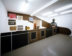 Daniela Brahm Hinterland, 2002 Mirko Mayer Gallery, Cologne “Hiding”, wooden fence “Participant / Mr. Nguvauva” cutouts, emulsion on wall paintings from the series “difficult characters”